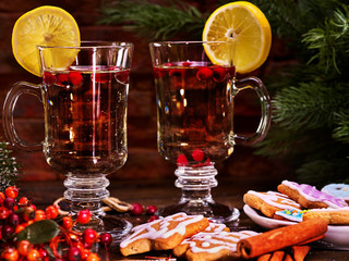 Fototapeta na wymiar Hot alcohol wine drink and Christmas cookie and canella stick lie foreground. Canella and glasses of hot wine still life .