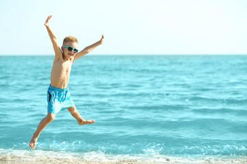 Fototapeta na wymiar Cute boy having fun on beach