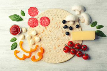 Raw pizza ingredients on wooden background, top view