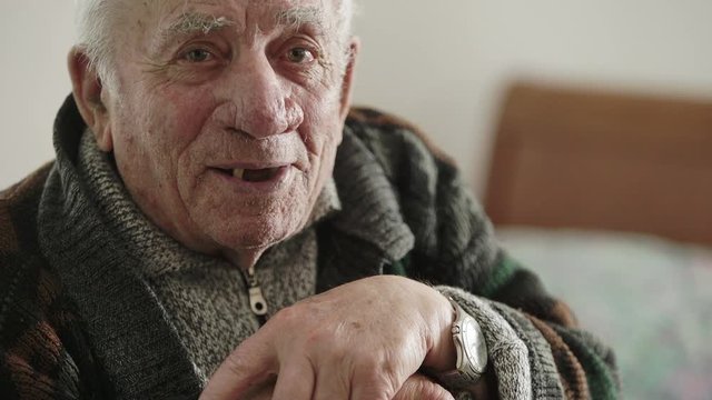 Toothless old man speaks to the camera