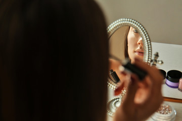 Young beautiful woman doing her make up