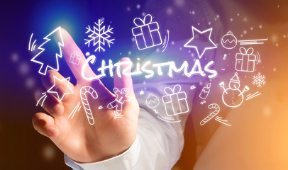 Hand of a man touching interface with christmas icon around