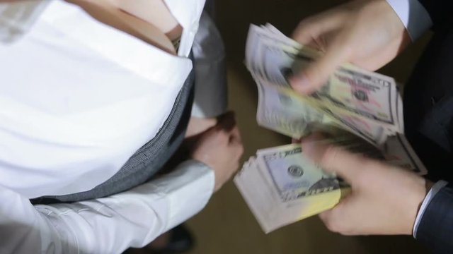 Beautiful young slim girl counts the money transferred to her man