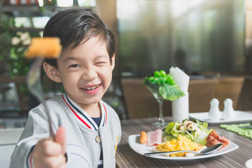 Asian child eating breakfast