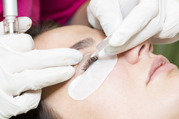 Woman on the procedure for eyelash extensions, eyelashes lamination