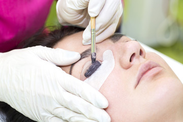 Woman on the procedure for eyelash extensions, eyelashes lamination