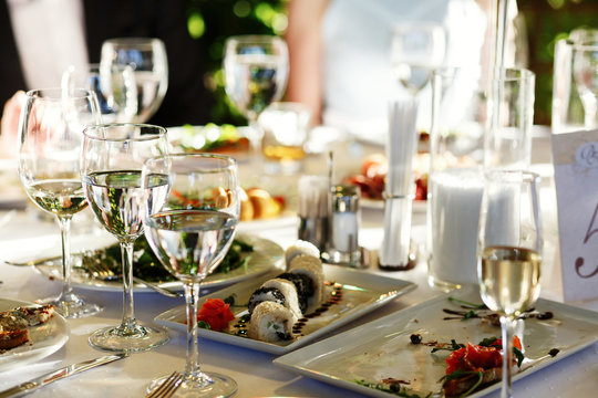 Glasses with wine and water stand on festive served dinner table