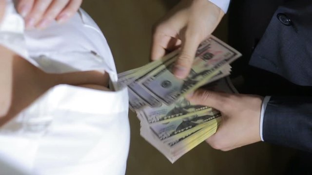 Beautiful young slim girl counts the money transferred to her man