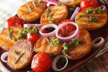 Vegetarian food: grilled new potatoes and tomatoes with rosemary macro on a plate. horizontal
