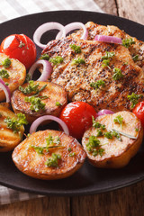 Chicken steak with grilled new potatoes and tomatoes close-up. vertical