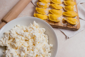 Ready for boiling vareniki, dumplings, pierogi on wooden cutting