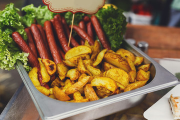 Street fast food, grilled sausages and potato wedges