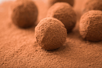Close up of group of appetizing black chocolate truffles covered