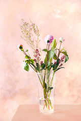Beautiful bouquet of flowers in glass vase on table in the room