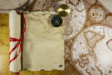 Old parchment paper and golden compass on world map