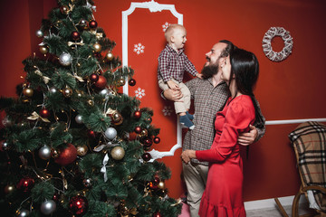 Christmas family portrait in home holiday living room, baby with parents, decorating house with...