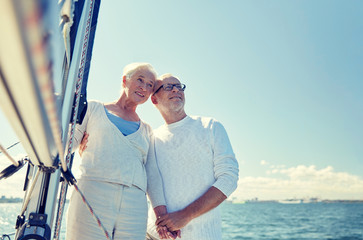 senior couple hugging on sail boat or yacht in sea