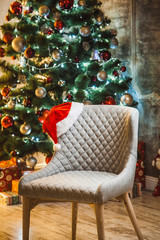 Beautiful New year room with a Christmas tree and a chair with a Santa hat