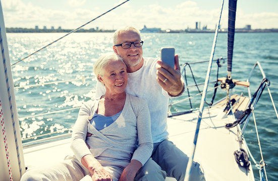 seniors with smartphone taking selfie on yacht