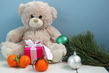 Плюшевый мишка, подарок и мандарины