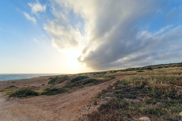 Dramatic sunset with storm cloudscape over Mediterranean Sea coastline fisheye view at sunset. Cape Greko, Cyprus.
