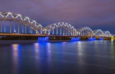 Obraz premium Nocturnal image with a railway bridge in Riga, Latvia