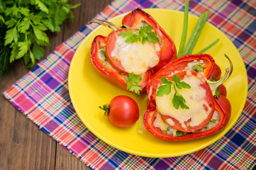 Stuffed bell peppers with rice and cheese. Wooden background. Close-up