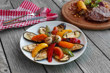 Grilled vegetables and mushrooms on dark wooden table background