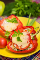 Stuffed bell peppers with rice and cheese. Wooden background. Close-up