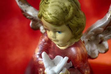 Angel with dove. Ceramic figurine of an Angel with a pigeon in his hands. Close-up image for...