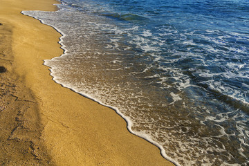 Sea wave covered Sandy beach. Clear seawater. Seacoast