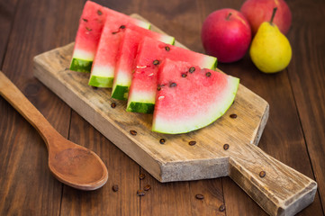 Watermelon sliced slices with a sprig of mint on  wooden background. Top view