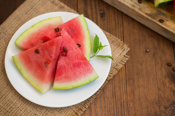 Watermelon sliced slices with a sprig of mint on  wooden background. Top view