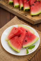 Watermelon sliced slices with a sprig of mint on  wooden background. Top view