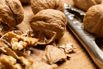 Nueces enteras y peladas sobre una tabla de madera rústica en primer plano. Vista de frente y de...