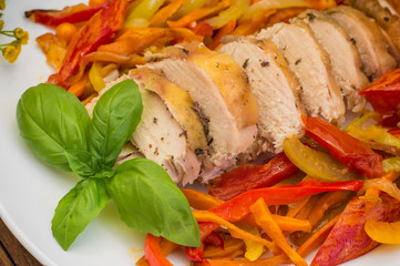 Roast duck breast with vegetable saute on a square plate. Wooden background. Top view. Close-up