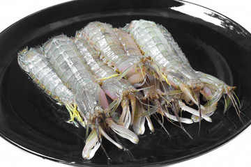 Fresh mantis shrimp seafood in black dish for cooking.