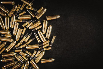 bullets from the gun placed on a black wooden table