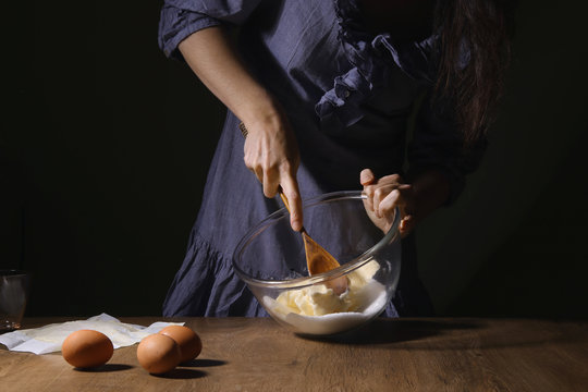 Women hands mixing sugar and butter  in bowl. Step of making cooking cake, preparing dough. Ingredients: butter, sugar, eggs.