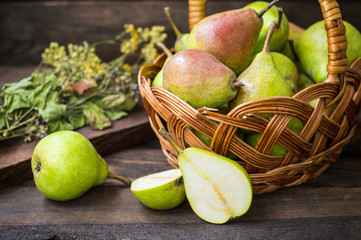 Ripe pears in a basket on  wooden background. Top view. Close-up