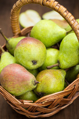 Ripe pears in a basket on  wooden background. Top view. Close-up
