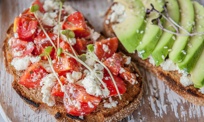 tasty and delicious bruschetta with with vegetables, cheese and micro greens