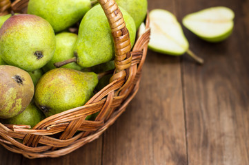 Ripe pears in a basket on  wooden background. Top view. Close-up