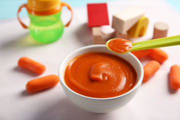 Bowl with healthy baby food on table. Child feeding concept