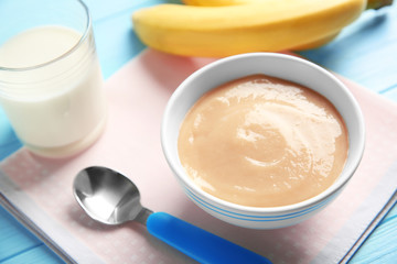 Bowl with healthy baby food on table. Child feeding concept