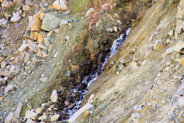 Small waterfall in the stone quarry on autumn
