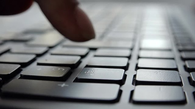 male hands working with a laptop in silhouette 