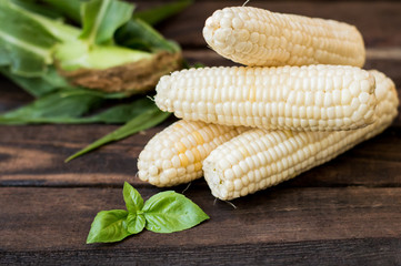 Fresh cobs of corn on the wooden background. Close-up