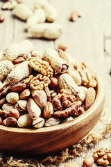Nuts mix, healthy and beneficial food, vintage wooden background