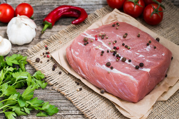Fresh veal with spices on a wooden background